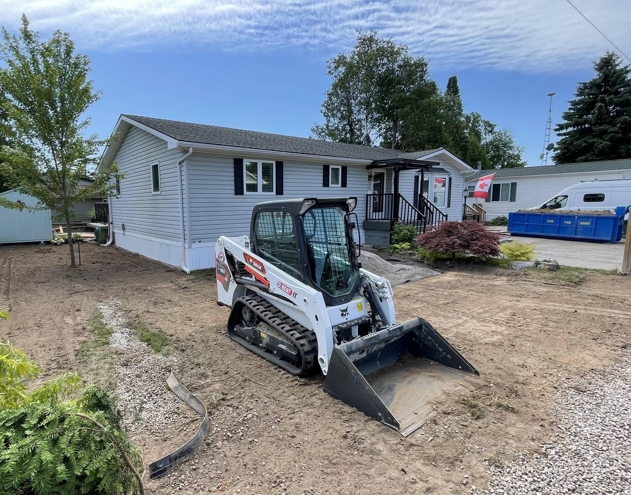 Skid steer doing grading of a residential house lot in Guelph