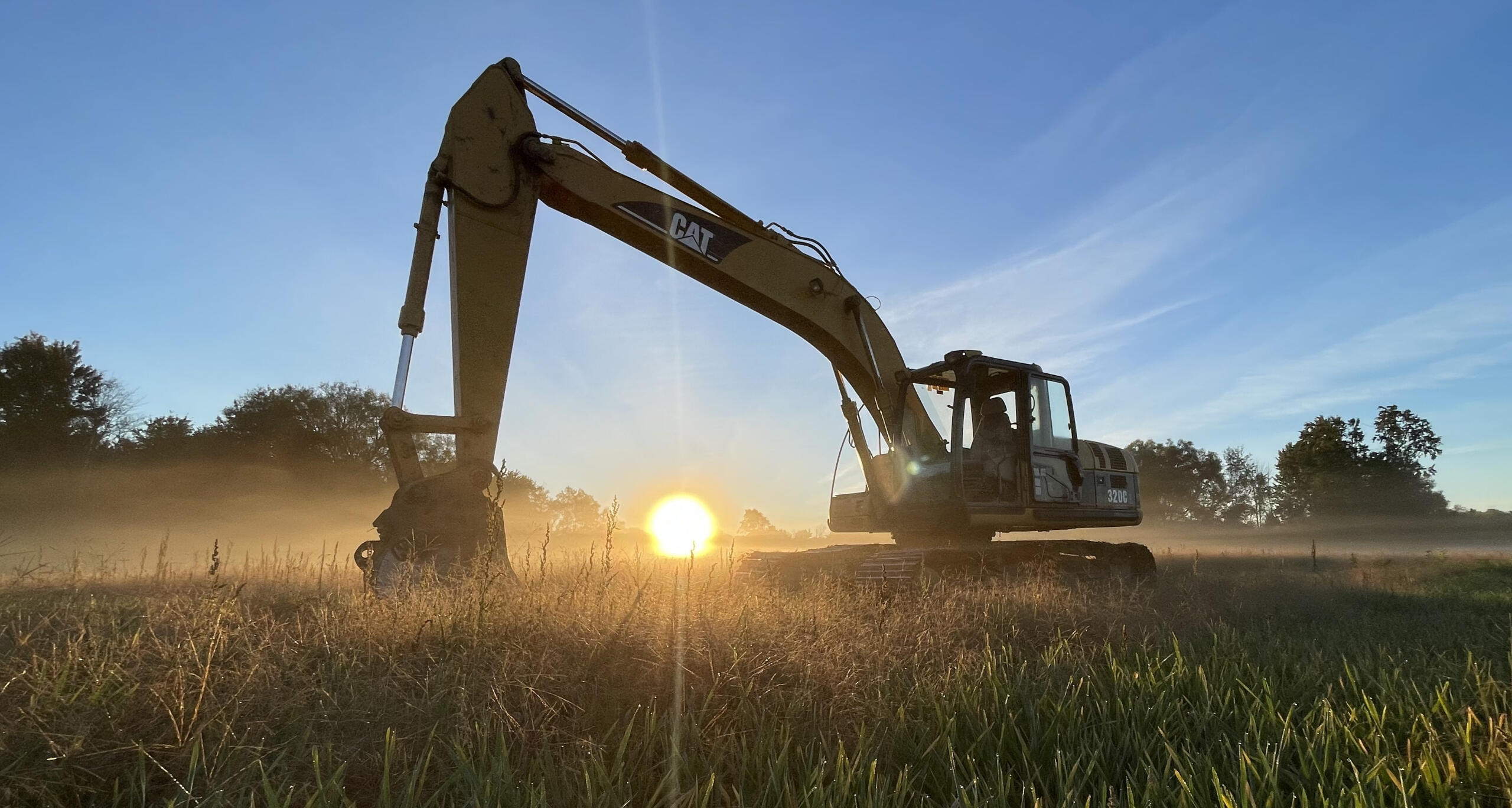 Excavator doing land clearing for farming project in Cambridge